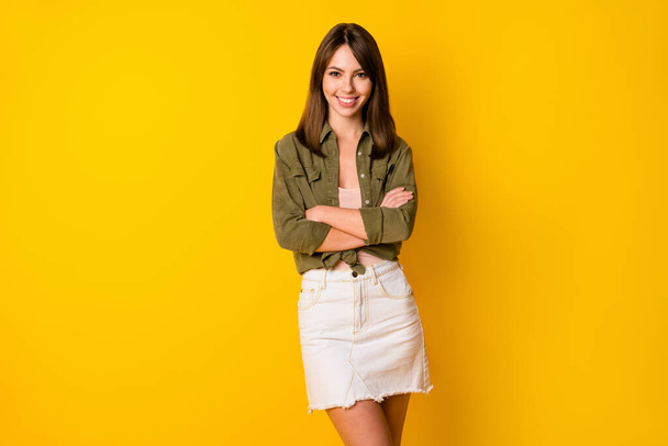 Photo of adorable young lady folded arms beaming smile look camera isolated on yellow color background. - Photo, image
