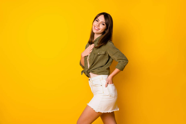 Profile portrait of positive person arm on chest toothy smile look camera isolated on yellow color background. - 写真・画像