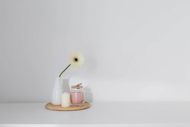 gerber with candles on white shelf - Фото, зображення