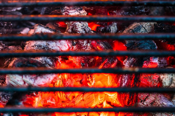 Гриль-піт барбекю з блискучими гарячими вугільними брикетами
 - Фото, зображення