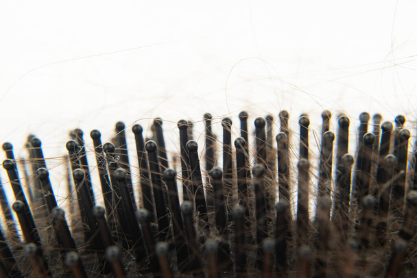 hair loss. wooden comb with burnt hair from stress or coronavirua on a white background.  - Fotoğraf, Görsel