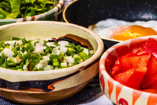 Diverse saladeingrediënten, tomatensaus, lekker gebakken ei en rauwe groenten voor een gezond ontbijt - Foto, afbeelding