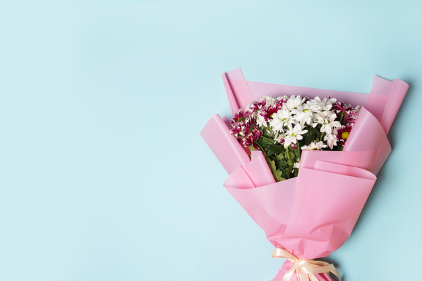 close-up van mooie bloem boeket met roze lint op blauwe achtergrond, Moederdag - Foto, afbeelding