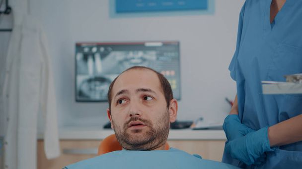 Pacjent z problemami z próchnicą otrzymujący konsultacje od zespołu stomatologicznego - Zdjęcie, obraz