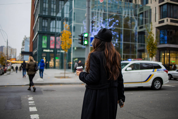 Postřelen krásnou mladou asijskou ženu přecházející ulici, držící smartphone a dívající se stranou v zimním čase. - Fotografie, Obrázek