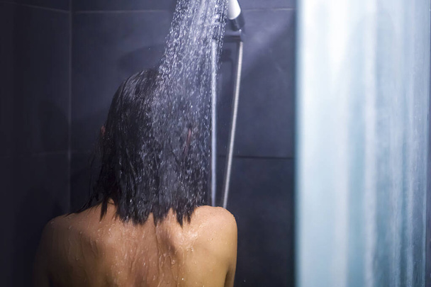 Dziewczyna bierze prysznic, myje włosy. - Zdjęcie, obraz