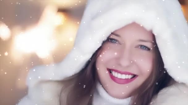Wintervakantie en kerstviering concept. Mooie glimlachende vrouw in witte pluizige bontjas met brandende sterretjes, sneeuw en sneeuwvlokken - Video
