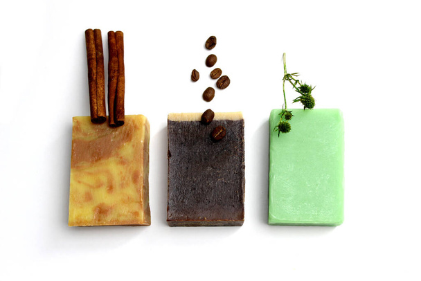 top view of various handcrafted soap with different ingredients in row on white surface. - Фото, изображение