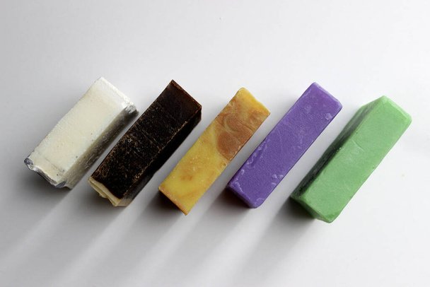 top view of various handcrafted soap with different ingredients in row on white surface. - Fotografie, Obrázek