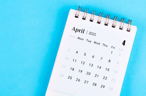 The mini April 2022 desk calendar on blue background. - Fotografie, Obrázek