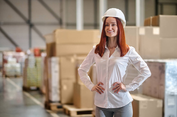 Woman holding hands on belt standing near boxes - Photo, Image