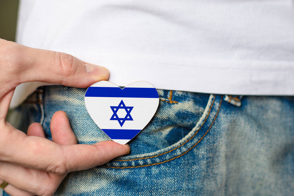 Patriot of the Israel! Wooden badge with Israel flag in the shape of a heart in a man's hand. - Fotografie, Obrázek