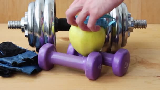 Healthy lifestyle. Dumbbells on a wooden background.  Apple snack - Filmati, video