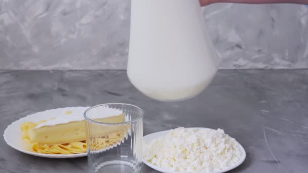 Leche. Productos lácteos. El queso y la leche se vierten en un vaso - Metraje, vídeo