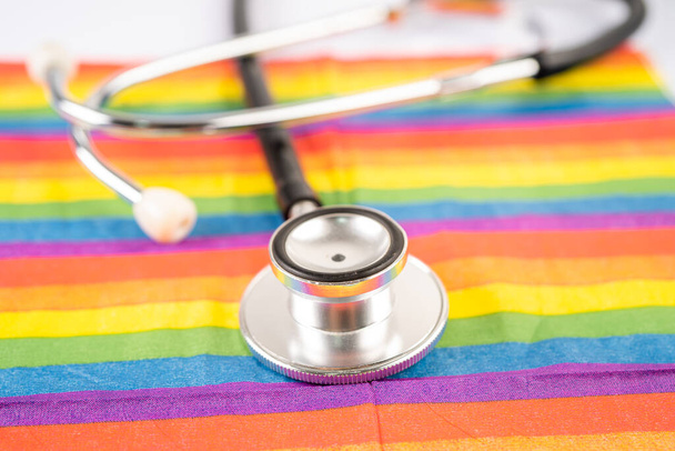 Czarny stetoskop na tle tęczowej flagi, symbol miesiąca dumy LGBT obchodzonego corocznie w czerwcu, symbol gejów, lesbijek, biseksualistów, transseksualistów, praw człowieka i pokoju. - Zdjęcie, obraz