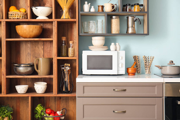 Wnętrze stylowej kuchni z ladą, kuchenką mikrofalową i półkami - Zdjęcie, obraz