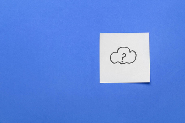 Nota adhesiva con nube dibujada y signo de interrogación sobre fondo azul - Foto, imagen
