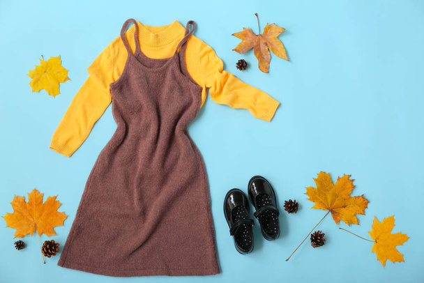 Kid clothes, shoes and autumn decor on blue background - Photo, Image