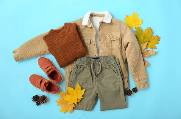 Set of stylish kid clothes and autumn decor on color background - Photo, Image
