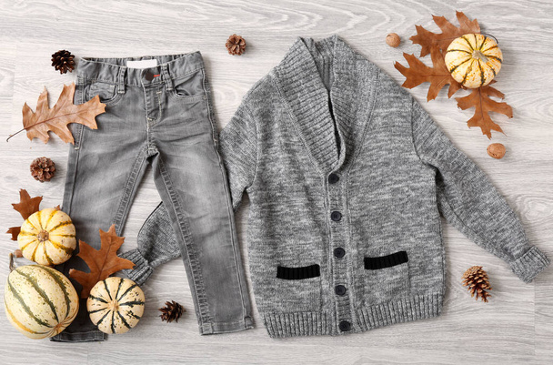 Ensemble de vêtements de bébé élégants et décor d'automne sur fond de bois gris - Photo, image