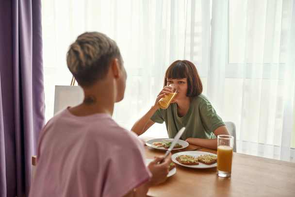Lesbian caucasian couple having breakfast at table - Foto, afbeelding