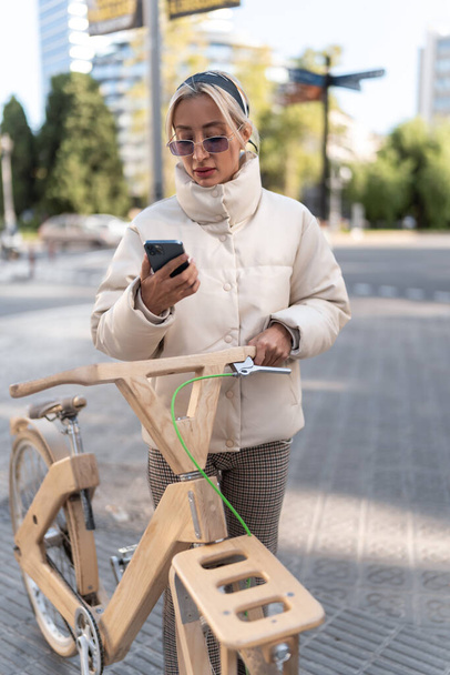 Female cyclist using cellphone on street - Foto, Imagem