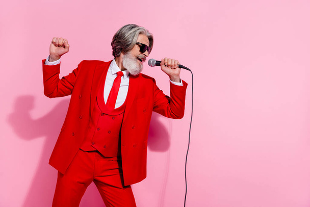 Portrait of attractive chic cheery grey-haired man mc showman singing hit rest pastime isolated over pink pastel color background - Photo, image