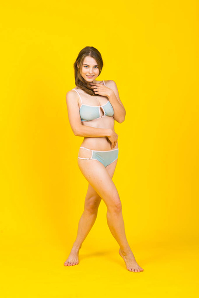 Seductive woman in a bikini having fun laughing with her long hair flying free - Fotografie, Obrázek