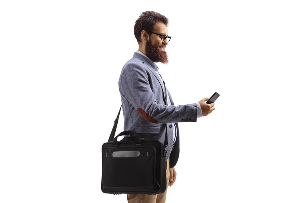 Man typing on a mobile phone and carrying a laptop bag isolated on white background - Foto, imagen