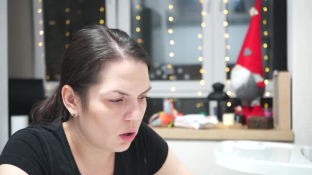 Höyryävä tyttö polttamassa sähkösavuketta sisätiloissa koristeltuna jouluksi. Hengenvaarallinen paha tapa. - Materiaali, video