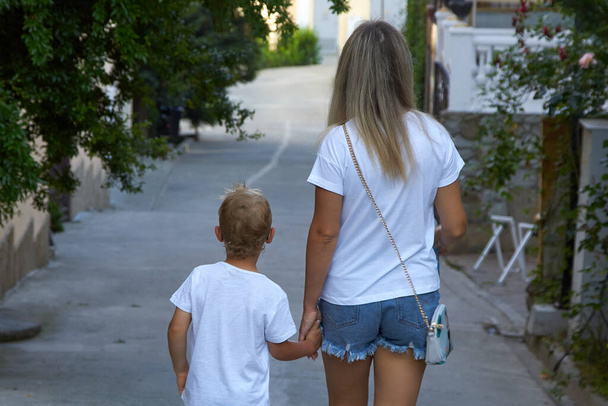 Woman and a child are walking around a beautiful tourist city. - Фото, зображення