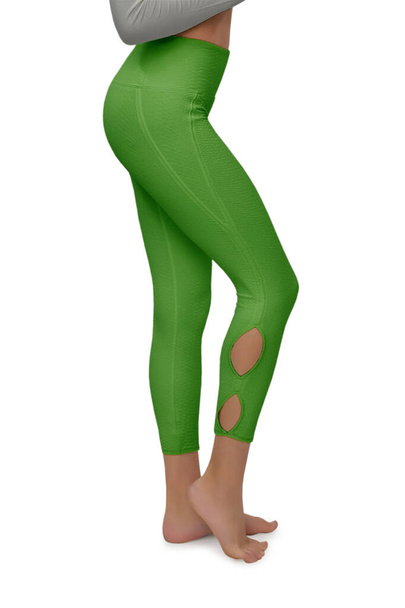 Piękne szczupłe kobiece nogi w zielone sportowe legginsy skórzane odizolowane na białym tle ze ścieżką wycinania. Pojęcie stylowych ubrań, sportu, piękna, mody i szczupłych nóg - Zdjęcie, obraz