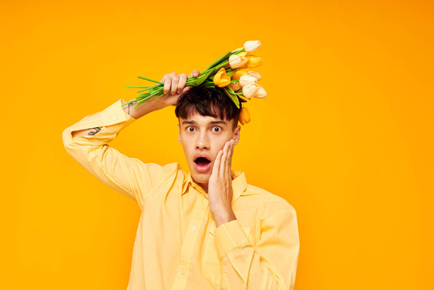 handsome guy with a fashionable hairstyle in yellow shirts with flowers yellow background unaltered - 写真・画像