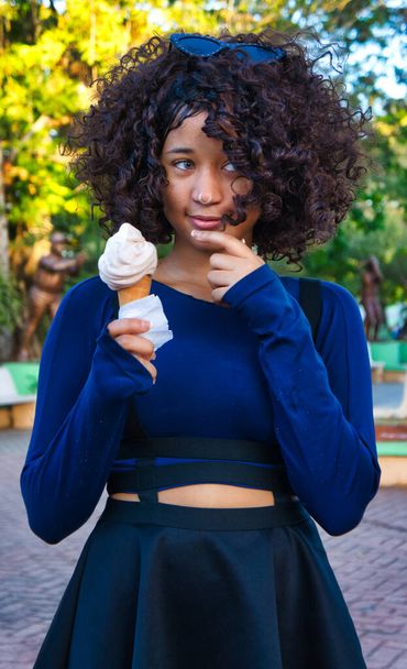 Girl goes out to the park and buys a strawberry ice cream to eat it - Foto, afbeelding