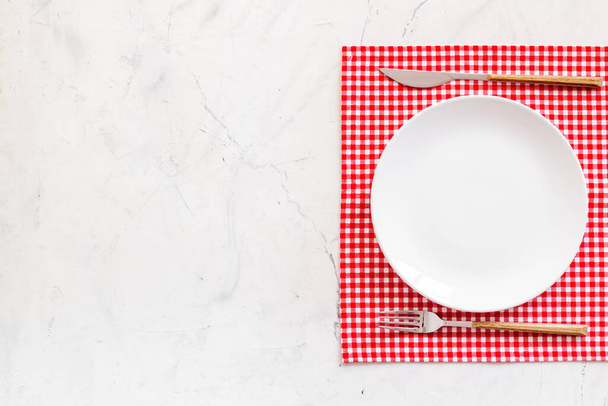 Empty dish and cutlery on napkin. Table setting top view - Фото, зображення