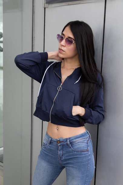 young latin female model with long straight black hair, wearing jeans, jacket and glasses while posing relaxed and sensual fit, lifestyle, beauty and casual fashion - Φωτογραφία, εικόνα