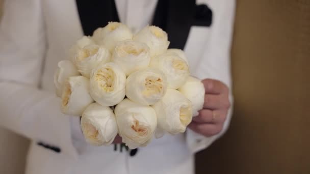 Sposo con bouquet da sposa in mano a casa che si prepara ad andare in sposa, primo piano al rallentatore - Filmati, video
