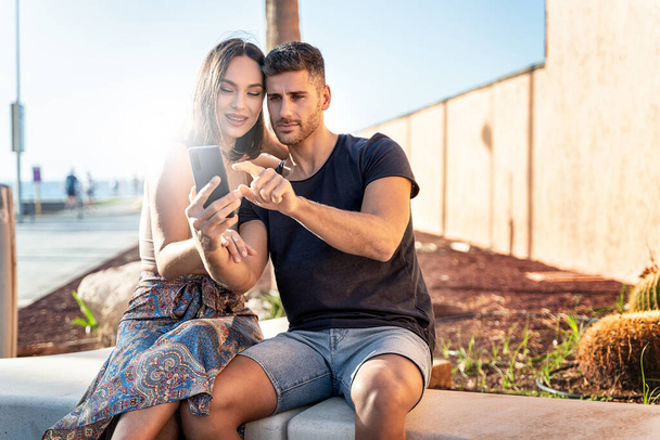 Young happy couple taking selfie with mobile phone, scrolling social media or talking online with friends. Summer time. Vacation. Traveler. Real people lifestyle. - Φωτογραφία, εικόνα
