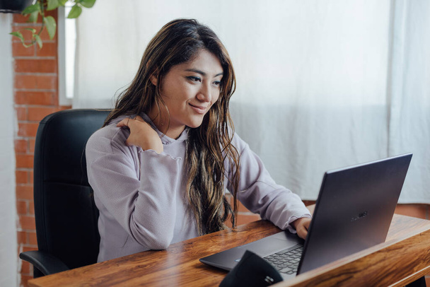Mexican woman with home office works happy in front of computer - Foto, Imagem