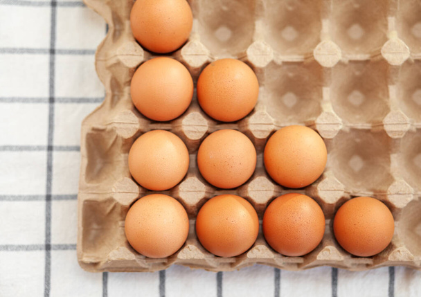 Kevés barna tojás egy nagy kartondoboz sejtjei között, csirke tojás, mint értékes tápláló termék, tálca a törékeny tojások szállítására és tárolására. Nem egy teljes csomag tojást, egy fontos élelmiszert. - Fotó, kép