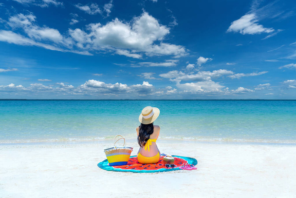 Молодая женщина в бикини отдыхает на пляже. Женщина отдыхает на белом песке с хрустальным морем тропического пляжа. - Фото, изображение