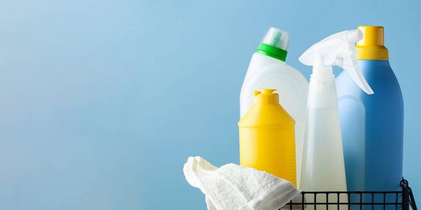Mockup van huishoudelijke wasmiddelen in een metalen mandje op een lichtblauwe achtergrond. - Foto, afbeelding