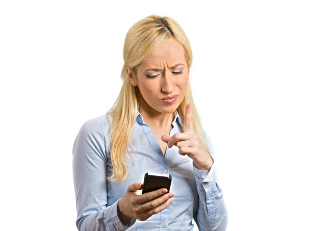angry young business woman pointing with finger at smartphone - Photo, image