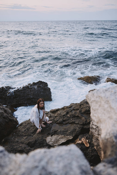 nő a sziklás kő fehér ruha óceán táj változatlan - Fotó, kép