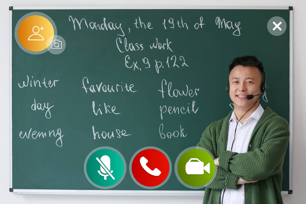 Asian male tutor conducting lesson online - Фото, зображення