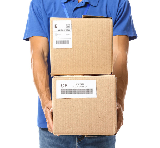 Male courier with parcels on white background, closeup - Fotó, kép