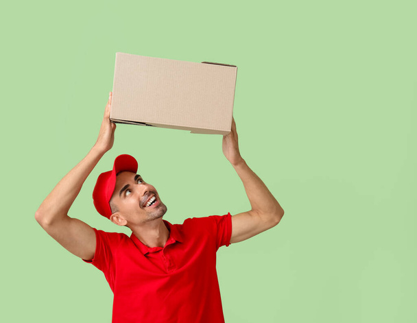 Male courier with parcel on color background - Foto, Imagen