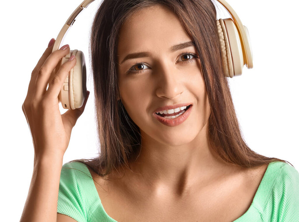 Cool young woman listening to music on white background - Foto, Imagem