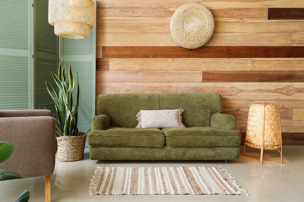 緑のソファとウィッカーランプとスタイリッシュなリビングルームのインテリア - 写真・画像