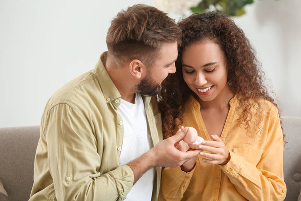 Junger Mann macht seiner Freundin zu Hause einen Heiratsantrag - Foto, Bild